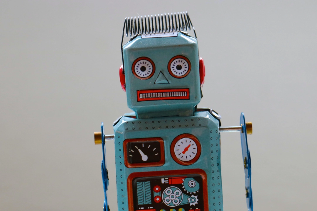 Vintage tin robot toy on a white background exemplifying functional programming principles in Python, symbolizing the automation and precision of code.