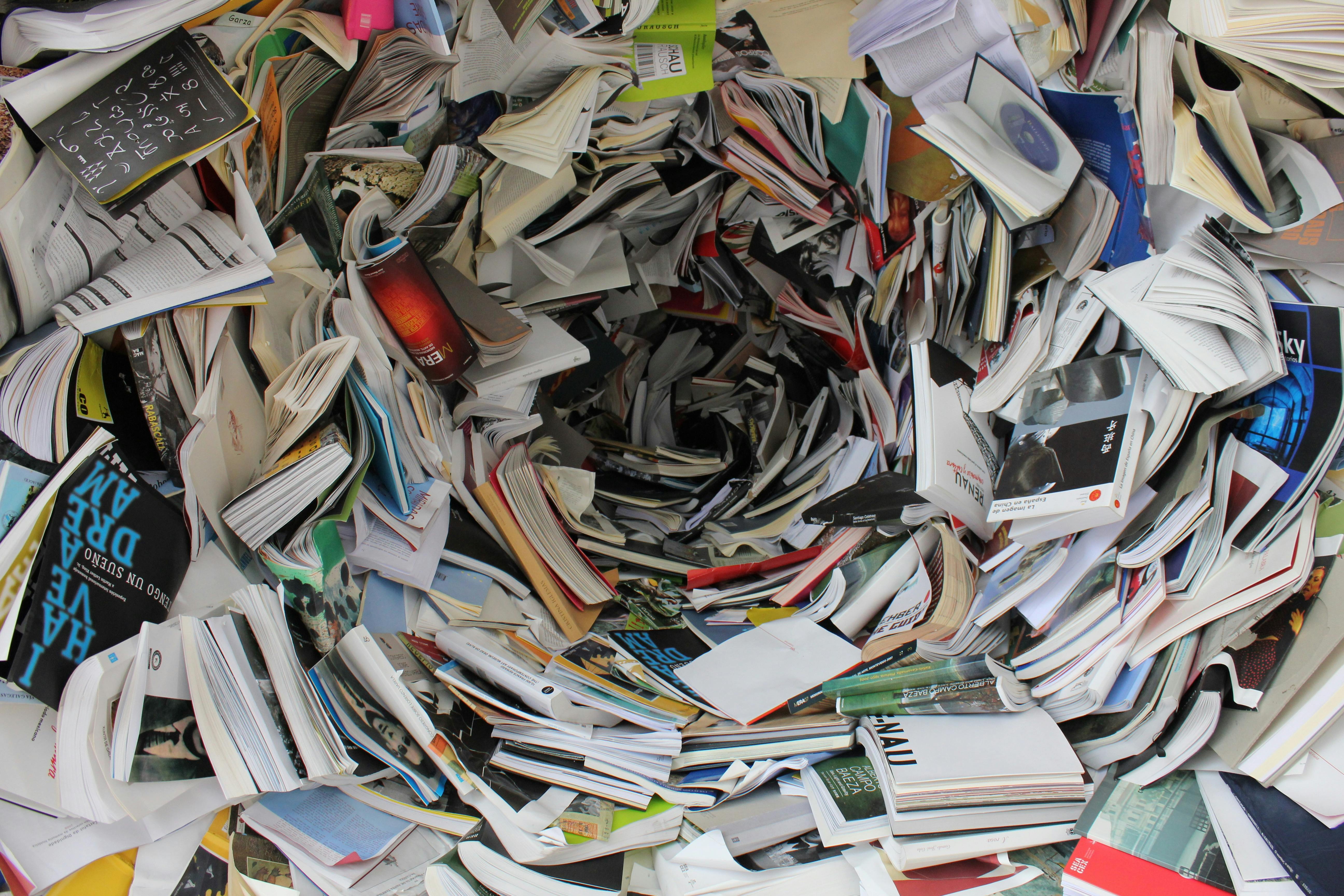 A chaotic pile of assorted books and printed materials haphazardly strewn about, visually representing the need for best practices for Python custom collections to organize data effectively.