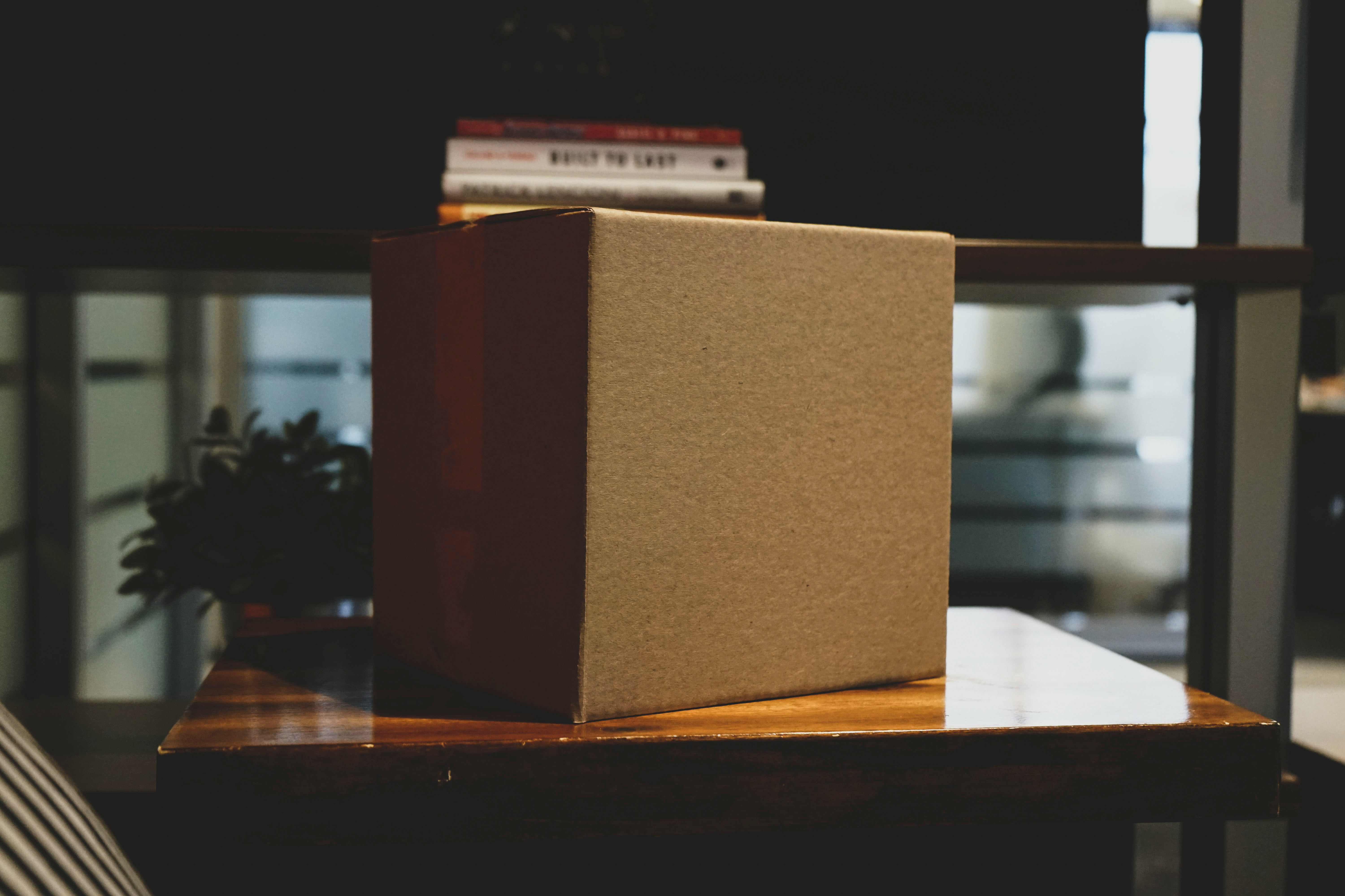 Cardboard box on a wooden table symbolizing the ease of packaging and publishing Python projects with Flit on PyPI, as if shipping a product.